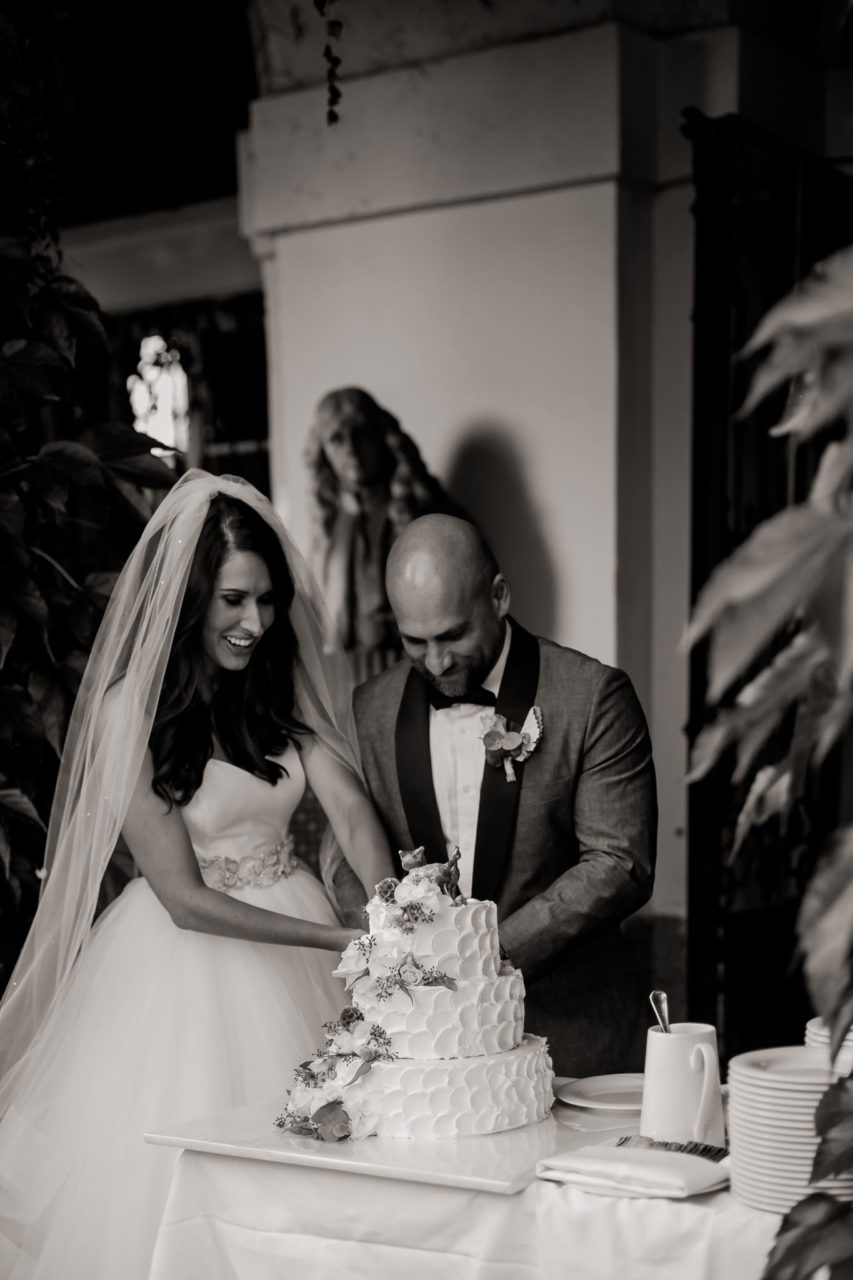 Hochzeitstorte mit echten Blumen-Hochzeitsfotograf Schloss Leopoldskron Salzburg-Hochzeitskuchen anschneiden